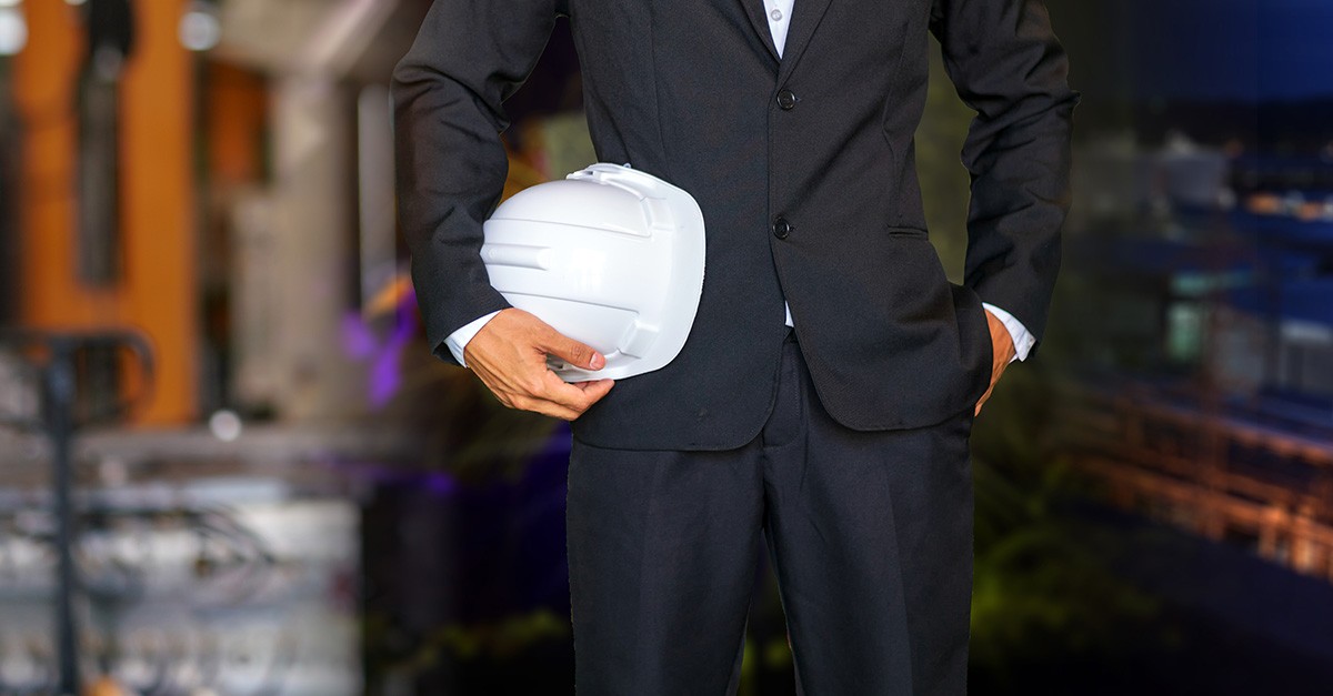 Engineer or Safety officer holding hard hat with construction site.